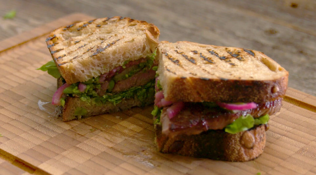 Lamb Roast Sandwich with Green Pea-Dill Pesto nicely cut in half