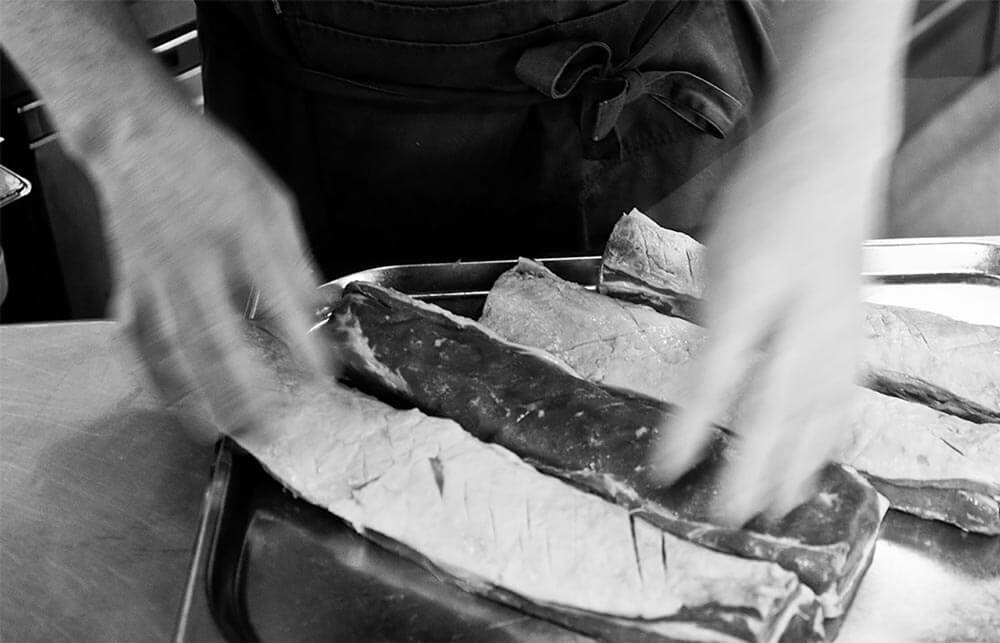 lamb meat being seasoned